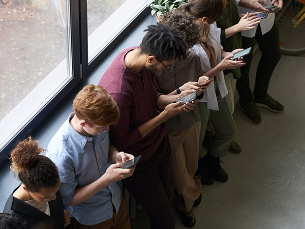 A photograph of people playing games on their mobile devices  - Chaos Theory | Serious Games Developer, Australia