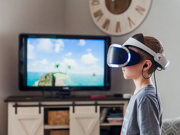 A photograph of a young boy using a virtual reality headset  - Chaos Theory | Serious Games Developer, Australia